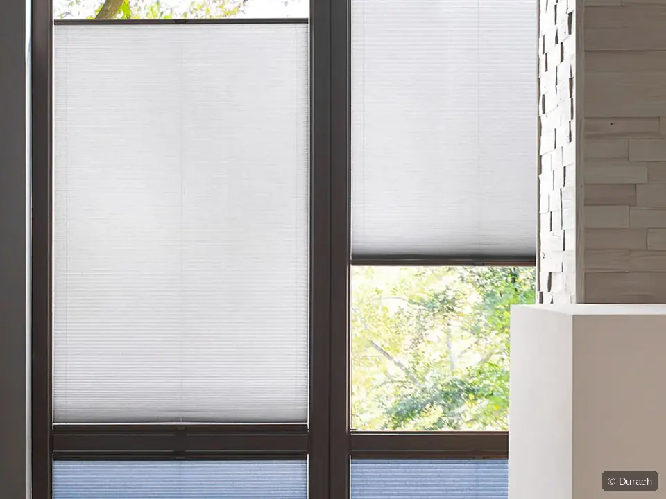 Durach Plissees in Weiß und Blau an einer bodentiefen Fensterfront
